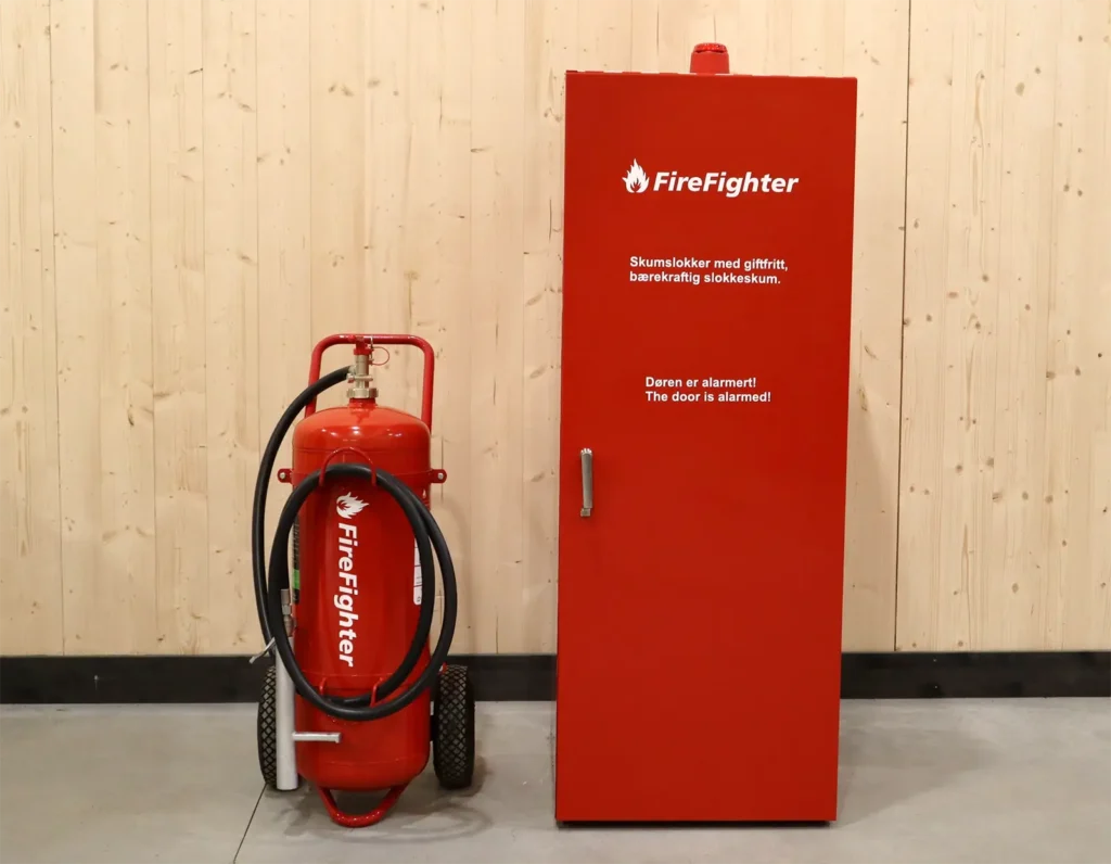Brannsikringsutstyrsstasjon med brannslukningsapparat og brannslukningsapparat, og alarmdør.
